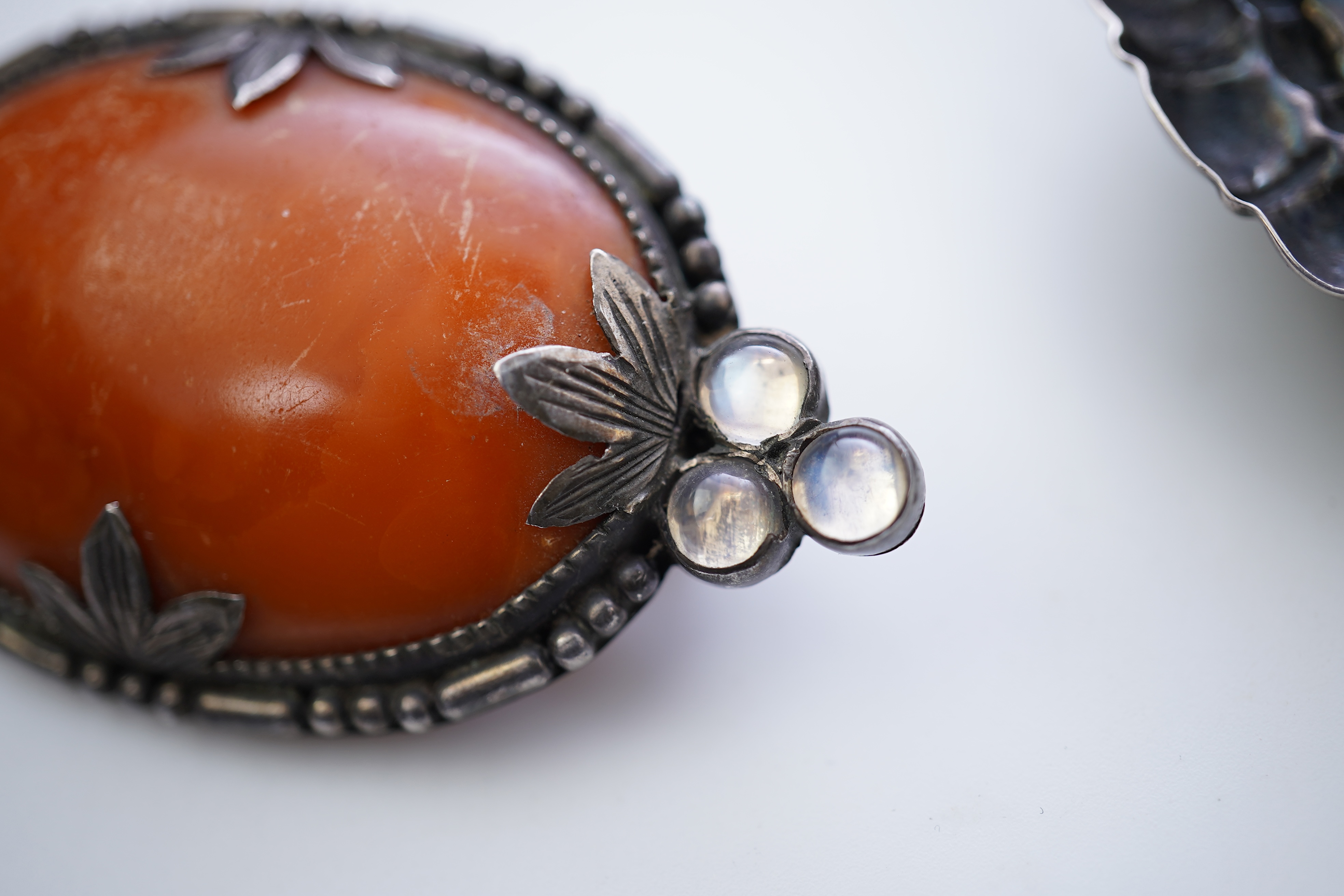 Three Arts & Crafts silver and amber brooches, early 20th century